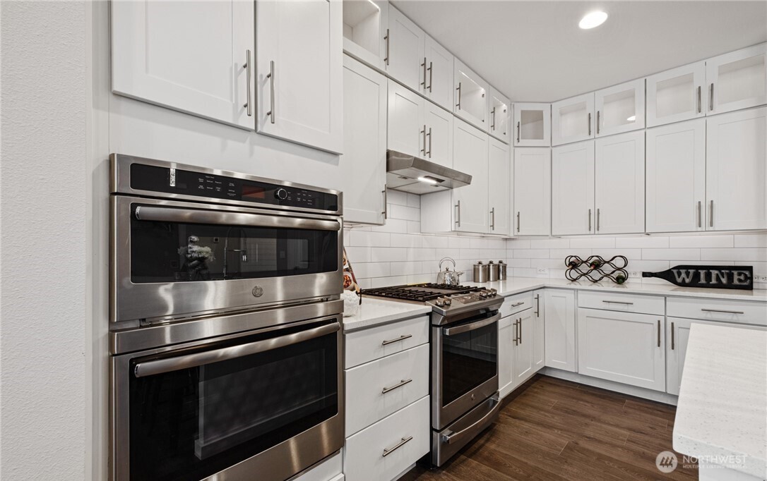 8831 27th Street East Edgewood, WA 98371 - Photo 12 of 27 a kitchen with stainless steel appliances white cabinets and a stove top oven