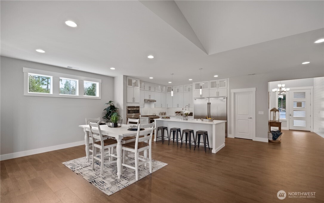8831 27th Street East Edgewood, WA 98371 - Photo 13 of 27 a view of a dining room with furniture wooden floor and chandelier