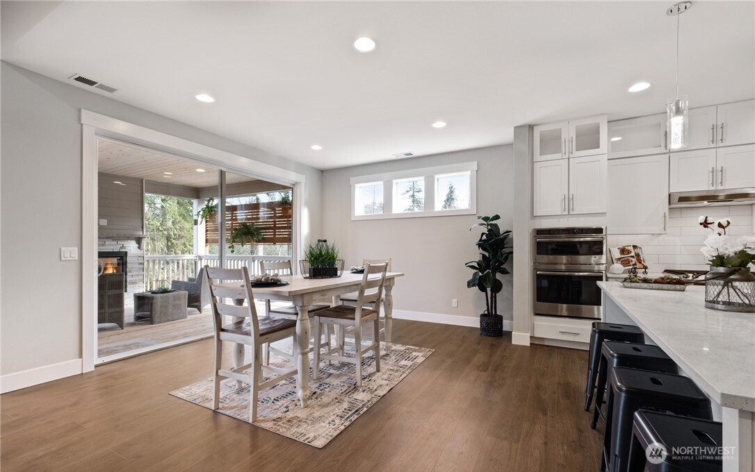 8831 27th Street East Edgewood, WA 98371 - Photo 14 of 27 a view of a dining room with furniture and wooden floor