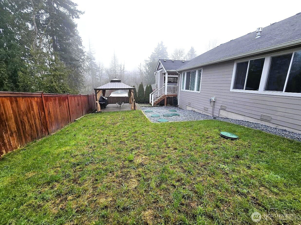 8831 27th Street East Edgewood, WA 98371 - Photo 26 of 27 a view of a backyard with table and chairs and wooden fence