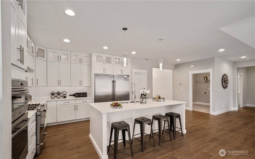 8831 27th Street East Edgewood, WA 98371 - Photo 9 of 27 a kitchen with stainless steel appliances kitchen island granite countertop a sink and cabinets