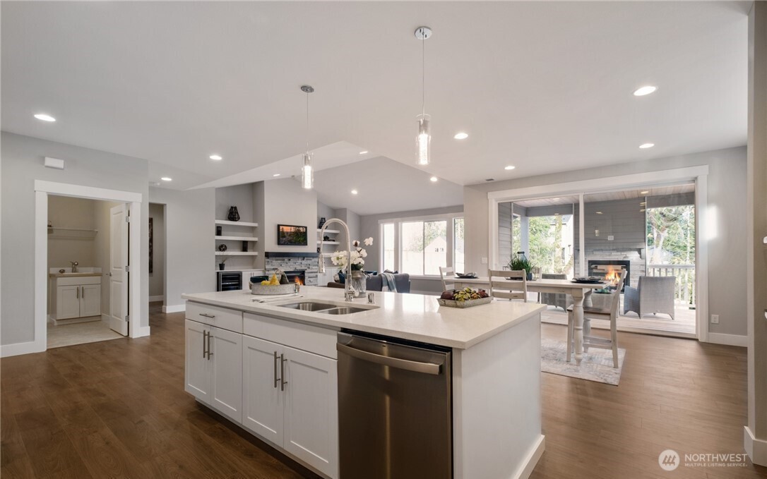 8831 27th Street East Edgewood, WA 98371 - Photo 10 of 27 a kitchen with a sink a stove and chairs with wooden floor