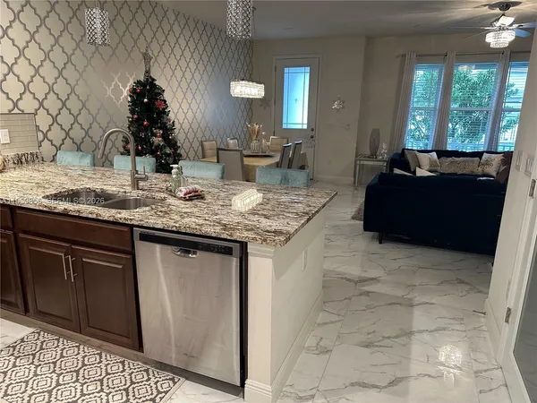 a kitchen with kitchen island granite countertop a sink stove and refrigerator