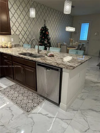a kitchen with granite countertop stainless steel appliances a sink and a counter space