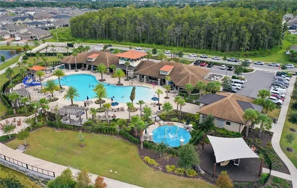an aerial view of a house with a garden and lake view