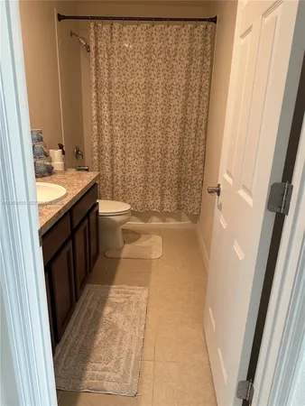 a bathroom with a granite countertop sink a toilet and a mirror