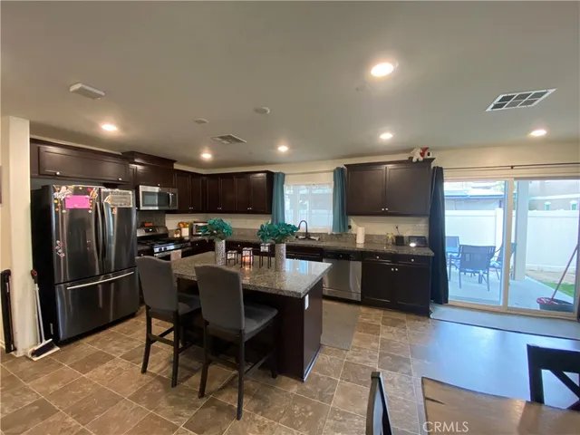 a view of kitchen with refrigerator stove dining table and chairs