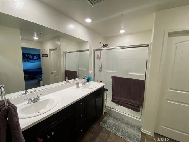 a bathroom with a double vanity sink mirror and shower