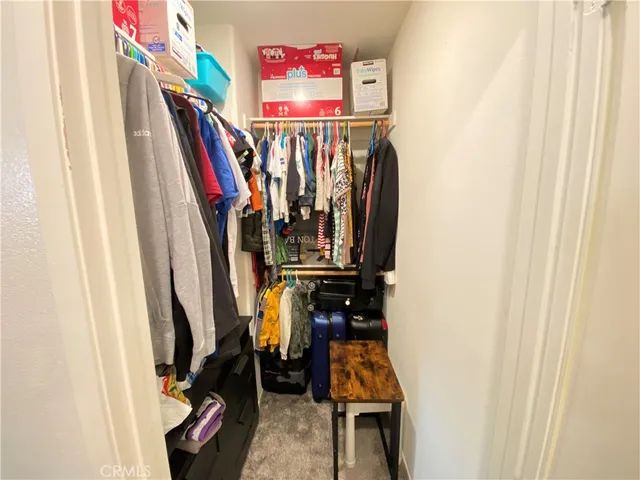 a view of walk in closet with clothes