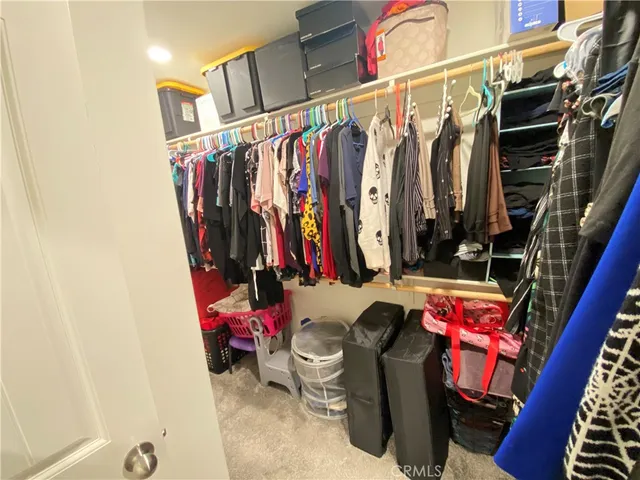 a view of walk in closet with clothes and shoes