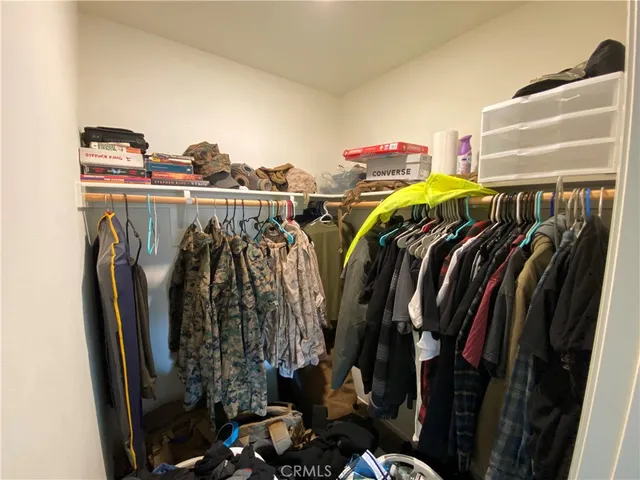 a view of walk in closet with clothes and shoes