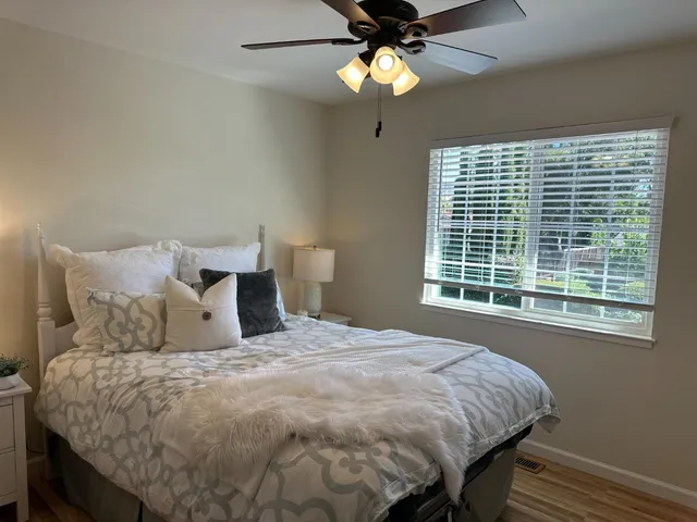 a large bed sitting in a bedroom next to a window and a chandelier