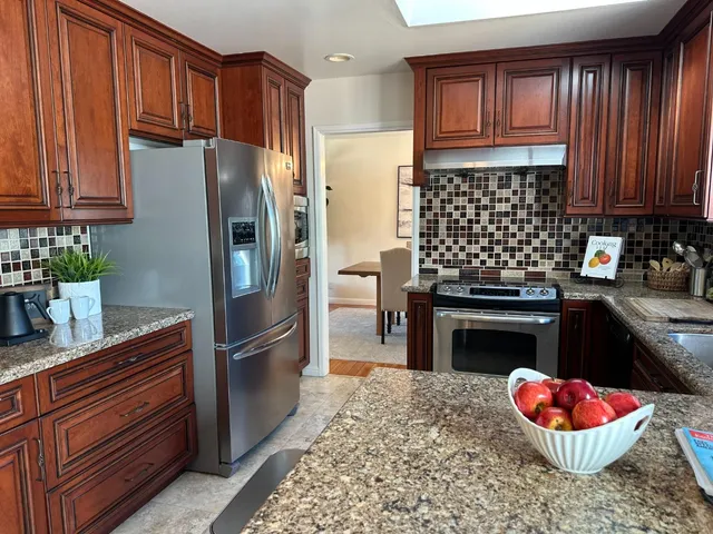 a kitchen with stainless steel appliances granite countertop a refrigerator stove and sink