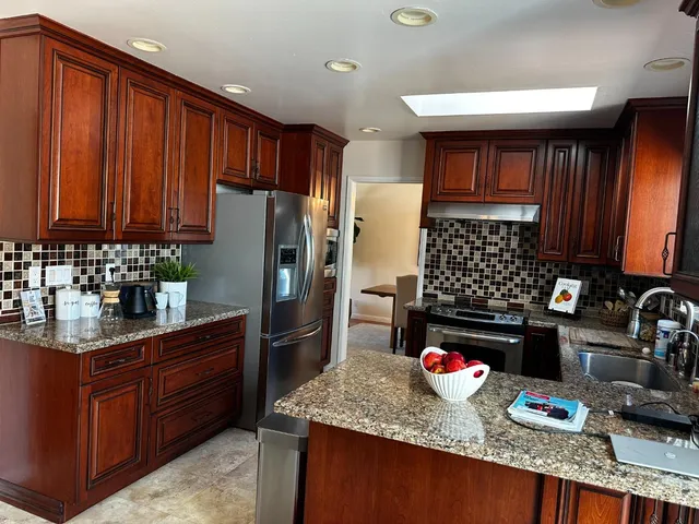 a kitchen with granite countertop stainless steel appliances and wooden cabinets