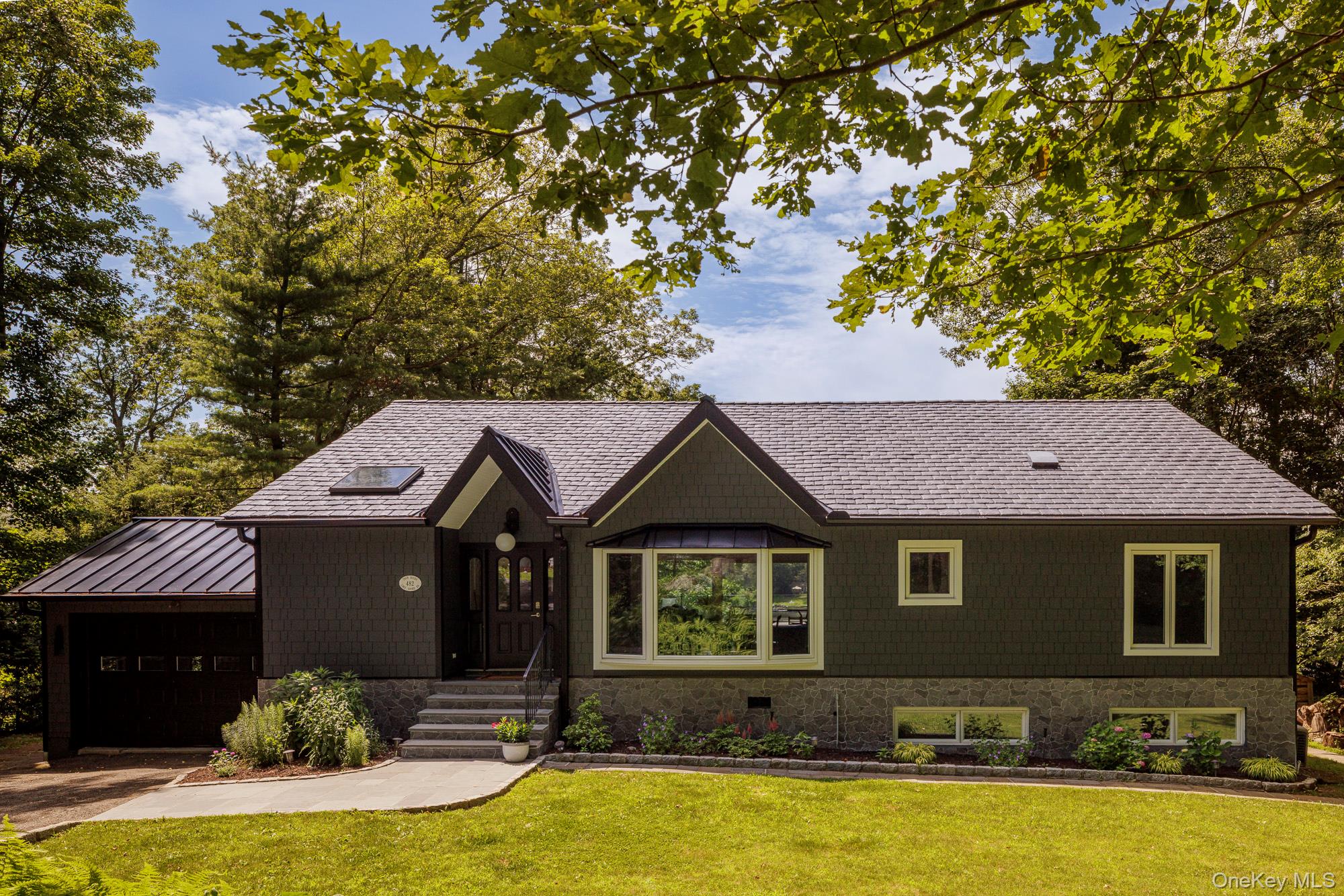 a front view of a house with yard and trees