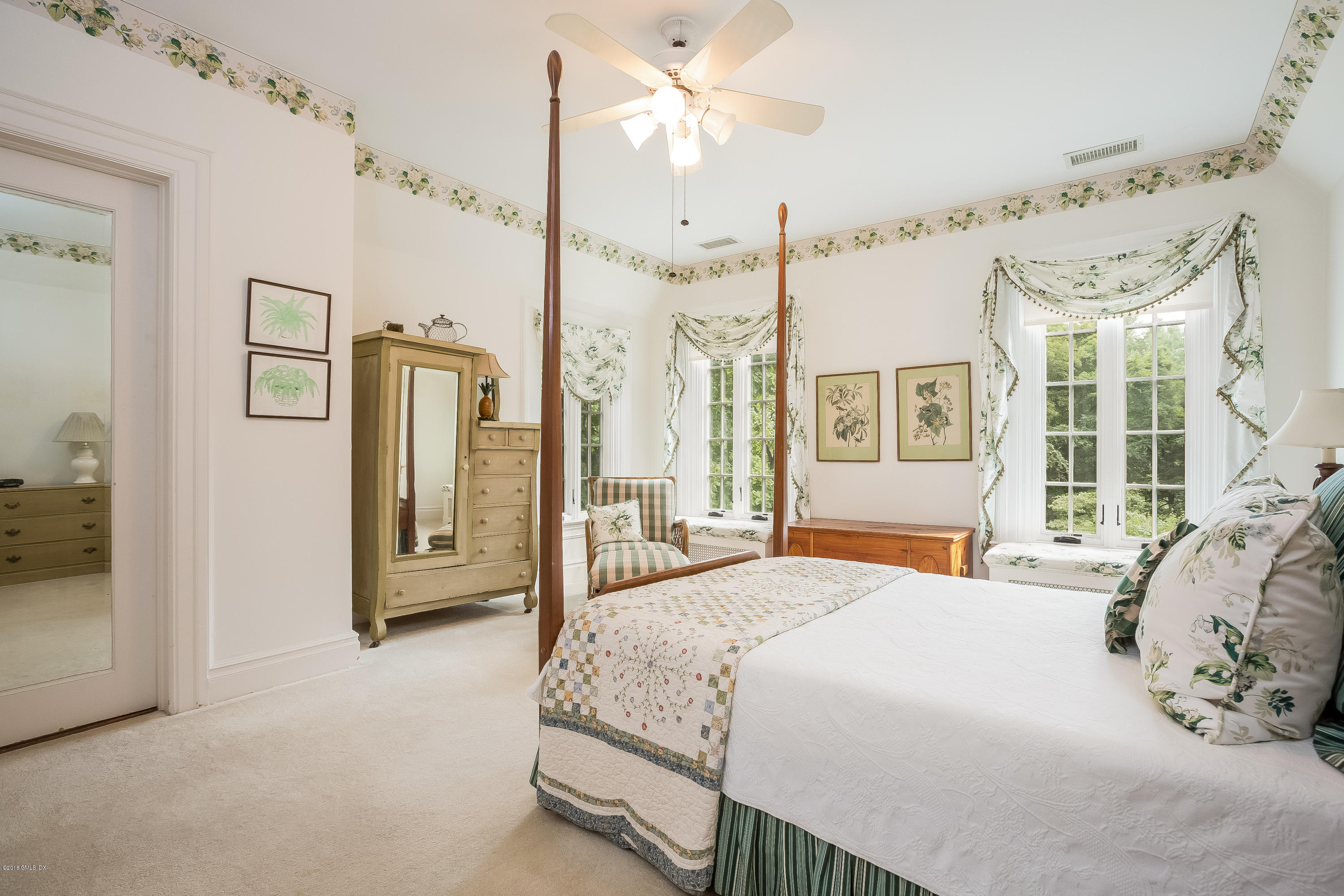 293 Shore Road Greenwich, CT 06830 - Photo 21 of 31 a spacious bedroom with a large bed and a chandelier