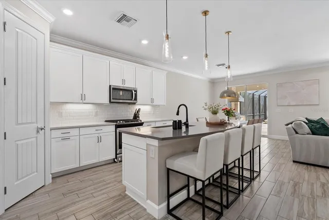 a kitchen with stainless steel appliances granite countertop a sink stove and wooden floor