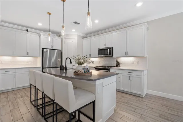 a kitchen with stainless steel appliances granite countertop a sink stove and microwave