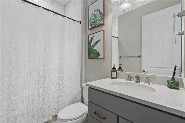 a bathroom with a granite countertop sink a toilet and a mirror