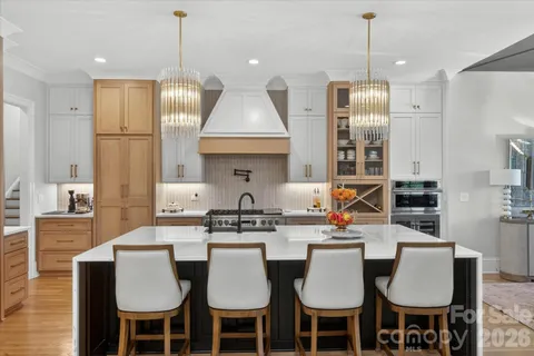 a kitchen with stainless steel appliances a table chairs stove and refrigerator