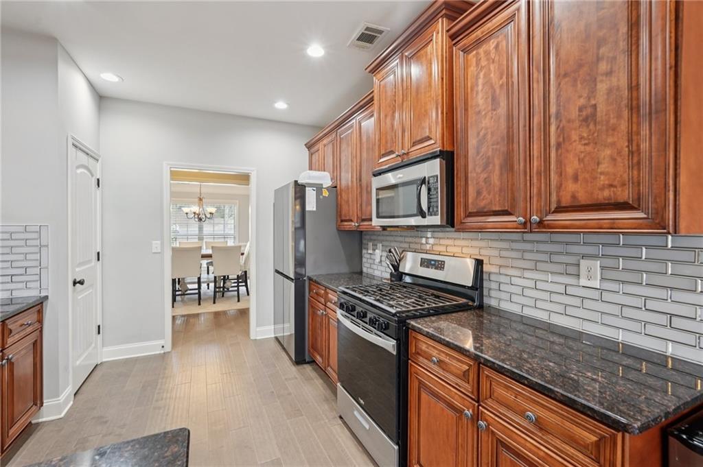 1330 Primrose Park Road Sugar Hill, GA 30518 - Photo 18 of 76 a kitchen with stainless steel appliances granite countertop a stove a sink and a microwave