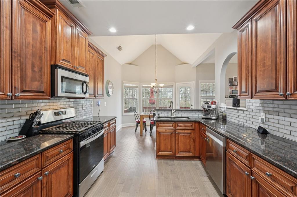 1330 Primrose Park Road Sugar Hill, GA 30518 - Photo 19 of 76 a kitchen with stainless steel appliances a sink stove and cabinets