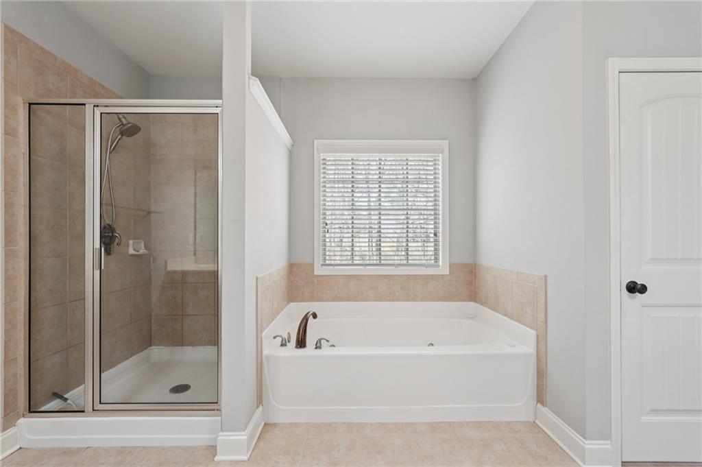 1330 Primrose Park Road Sugar Hill, GA 30518 - Photo 38 of 76 a bathroom with a bathtub and shower