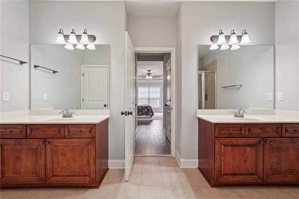 1330 Primrose Park Road Sugar Hill, GA 30518 - Photo 39 of 76 a spacious bathroom with a double vanity sink a mirror a lamp a bathtub and shower