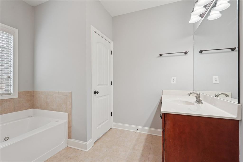 1330 Primrose Park Road Sugar Hill, GA 30518 - Photo 41 of 76 a bathroom with a tub sink and mirror