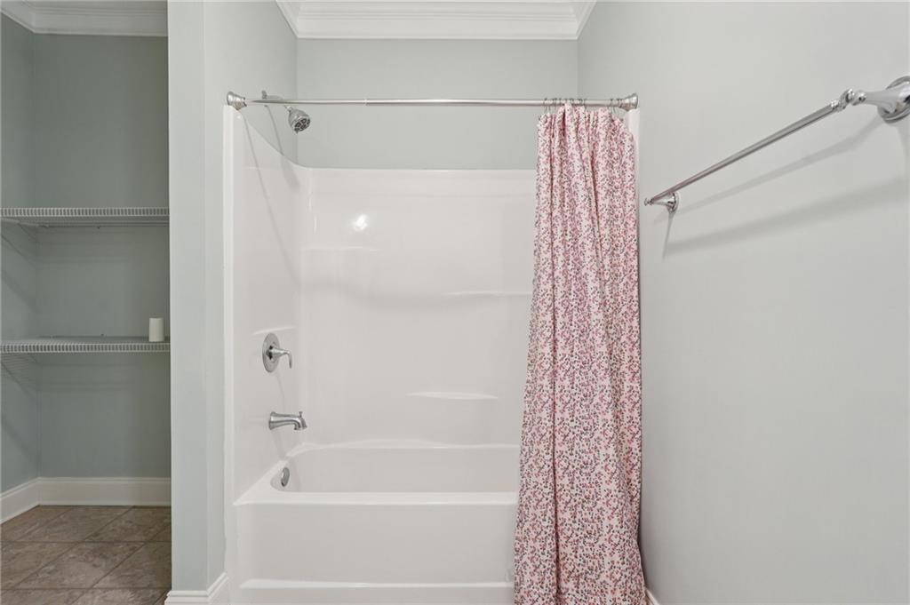 1330 Primrose Park Road Sugar Hill, GA 30518 - Photo 47 of 76 a bathroom with a shower curtain and a bathtub