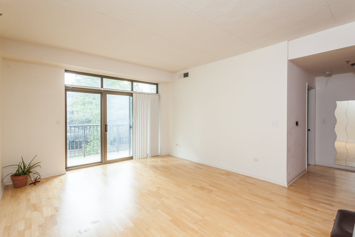 1250 South Indiana Avenue, Unit 812 Chicago, IL 60605 - Photo 3 of 23 an empty room with wooden floor and windows