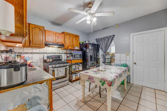 a open kitchen with stainless steel appliances granite countertop a stove top oven a sink dishwasher and cabinets with wooden floor