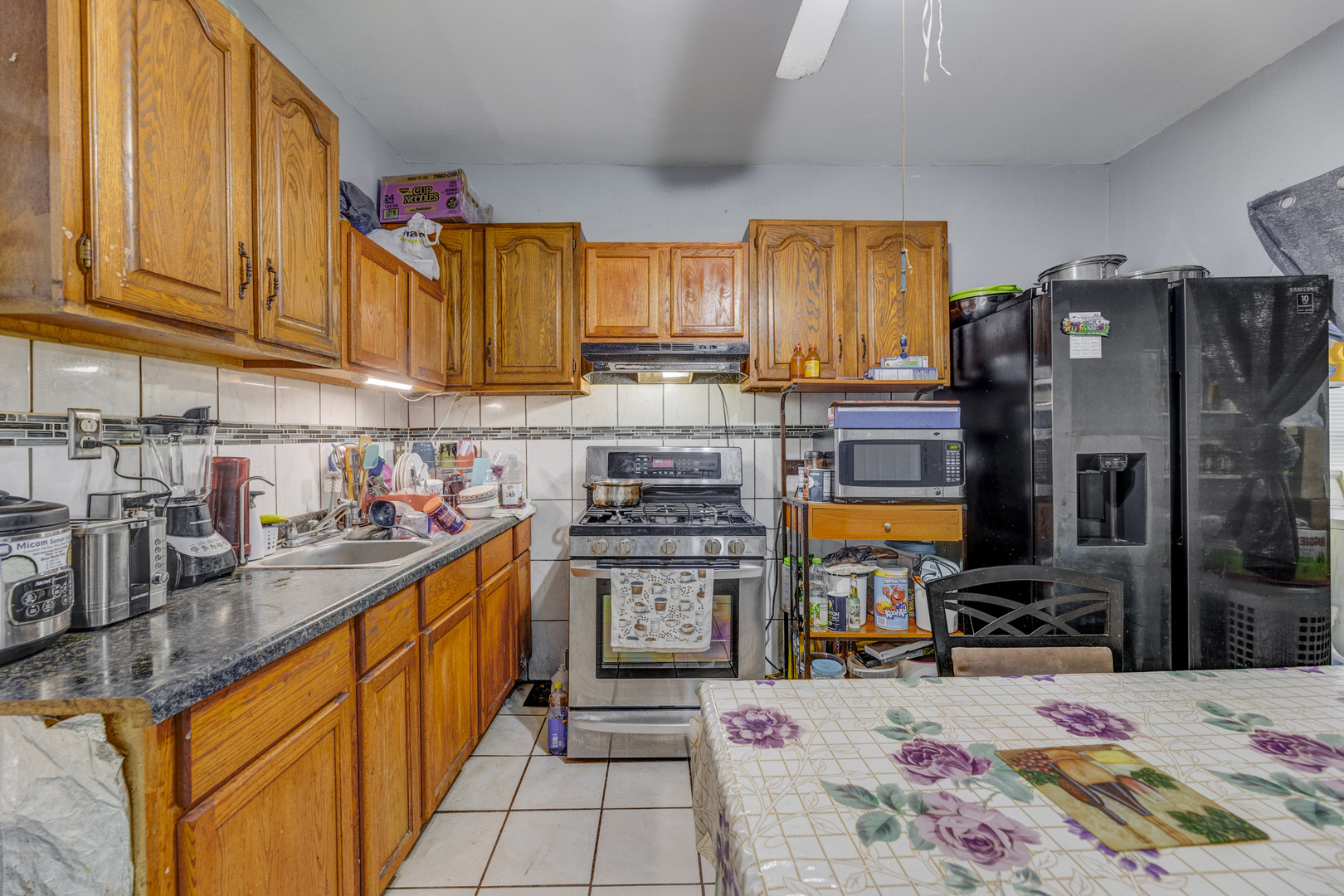 2208 West 54th Place Chicago, IL 60609 - Photo 7 of 18 a kitchen with stainless steel appliances wooden cabinets and a stove top oven