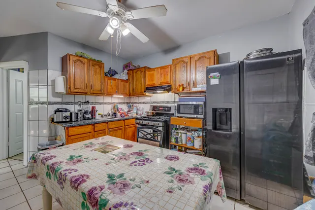 a kitchen with stainless steel appliances kitchen island granite countertop a refrigerator a stove and a sink with dishwasher
