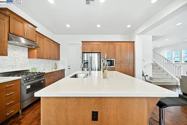 a kitchen with stainless steel appliances a sink stove and cabinets