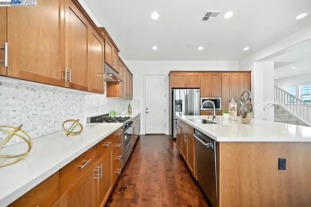 a kitchen with stainless steel appliances granite countertop a sink stove and cabinets
