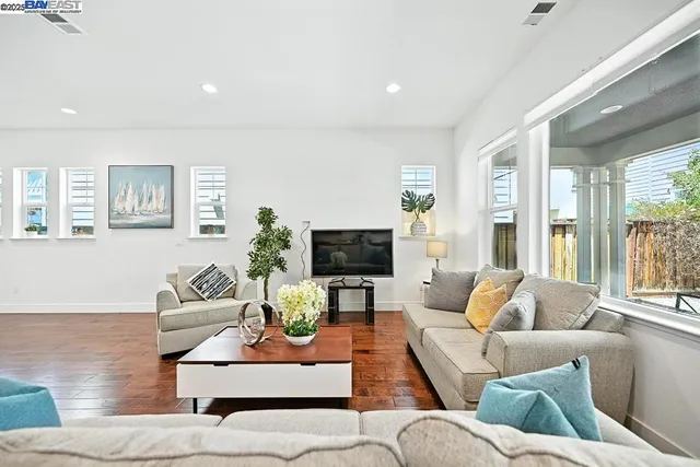 a living room with furniture and view of kitchen