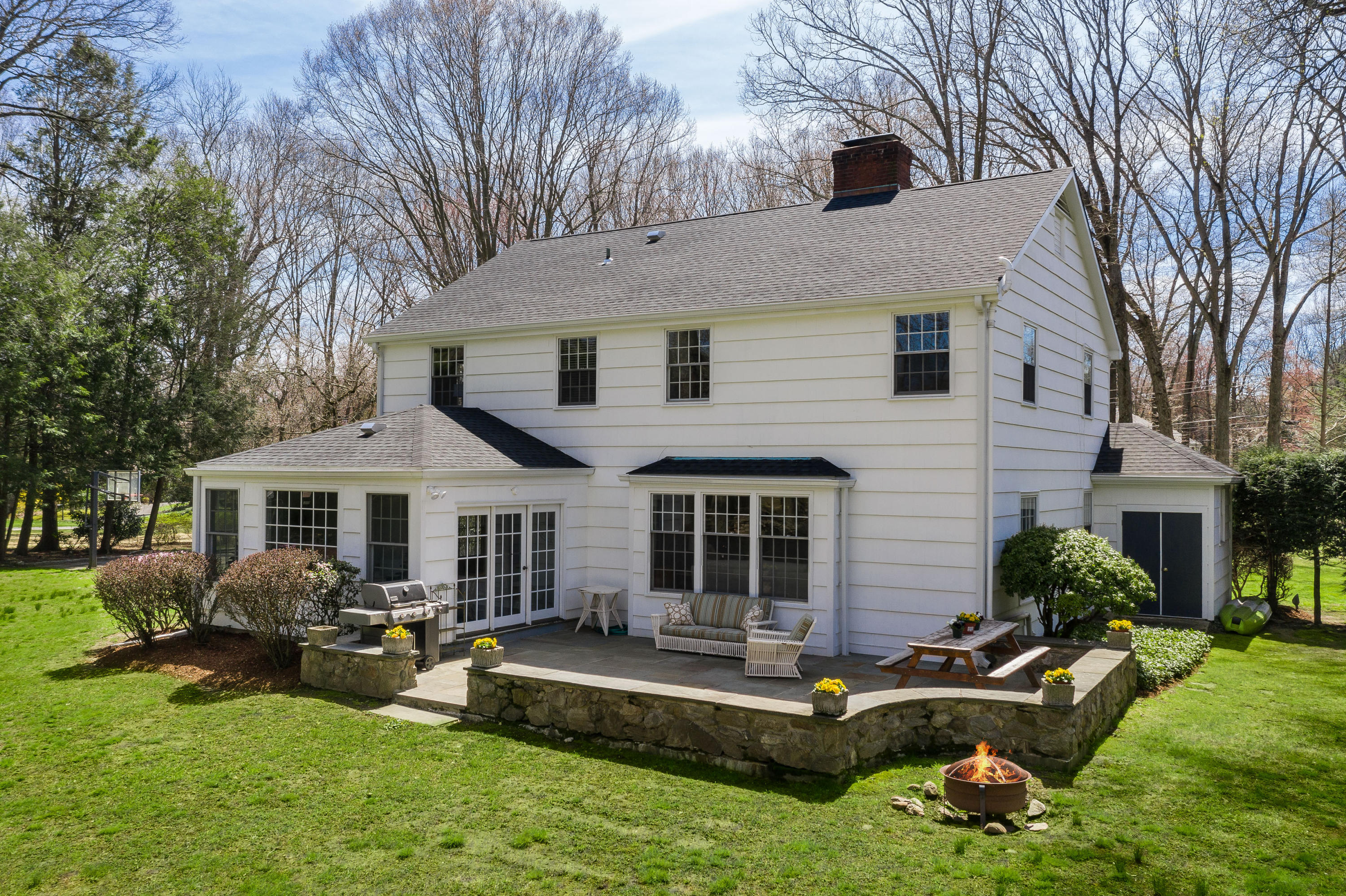 3 Haskell Lane Darien, CT 06820 - Photo 15 of 21 a front view of a house with a yard table and chairs