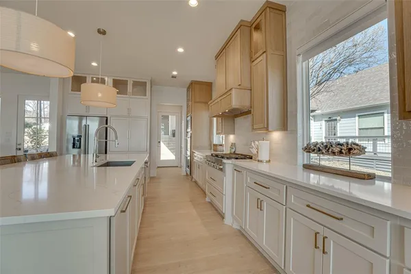 a large kitchen with stainless steel appliances lots of counter space and a wooden floor