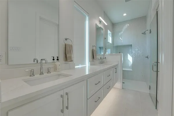 a bathroom with double vanity sink and mirror