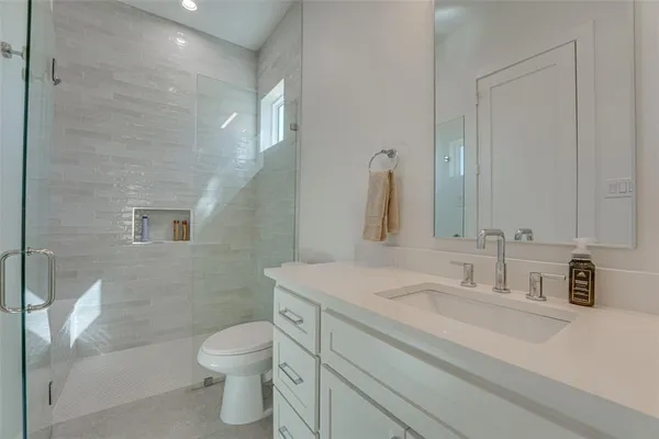 a bathroom with a sink toilet vanity and shower