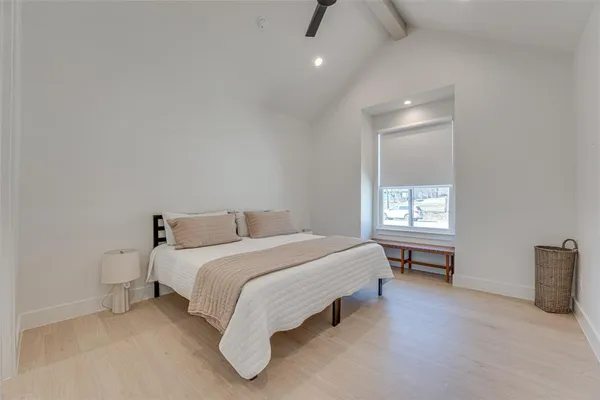 a spacious bedroom with a bed and a window