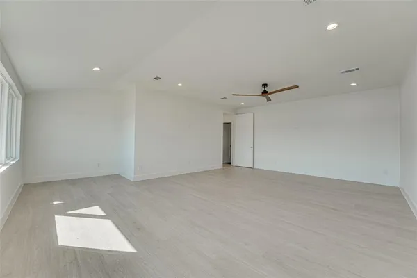 an empty room with an entryway and fan