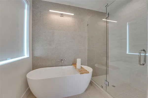a white bath tub sitting next to a shower