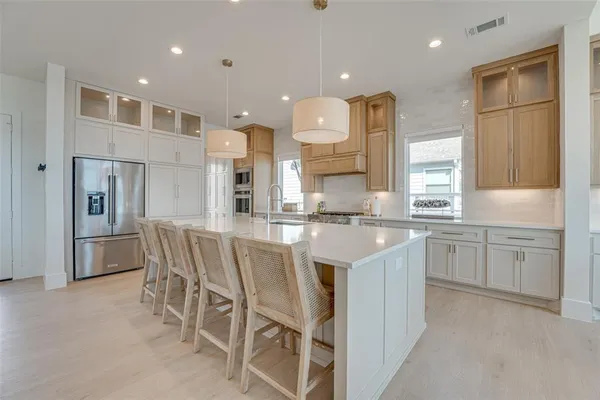 a large kitchen with kitchen island granite countertop lots of white cabinets appliances and furniture