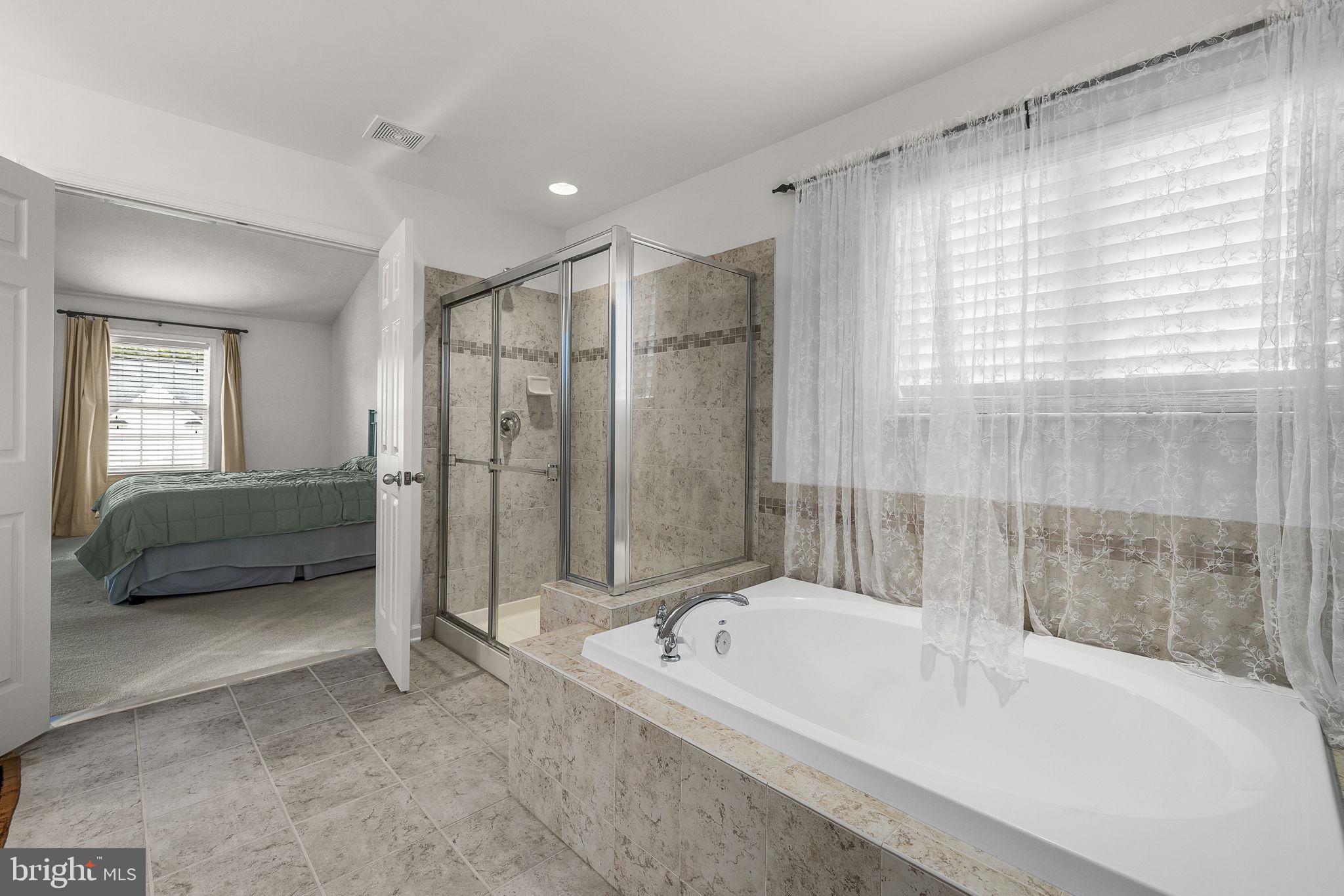 192 Matchbox Court Ranson, WV 25438 - Photo 21 of 50 a bathroom with a tub a sink and a large mirror
