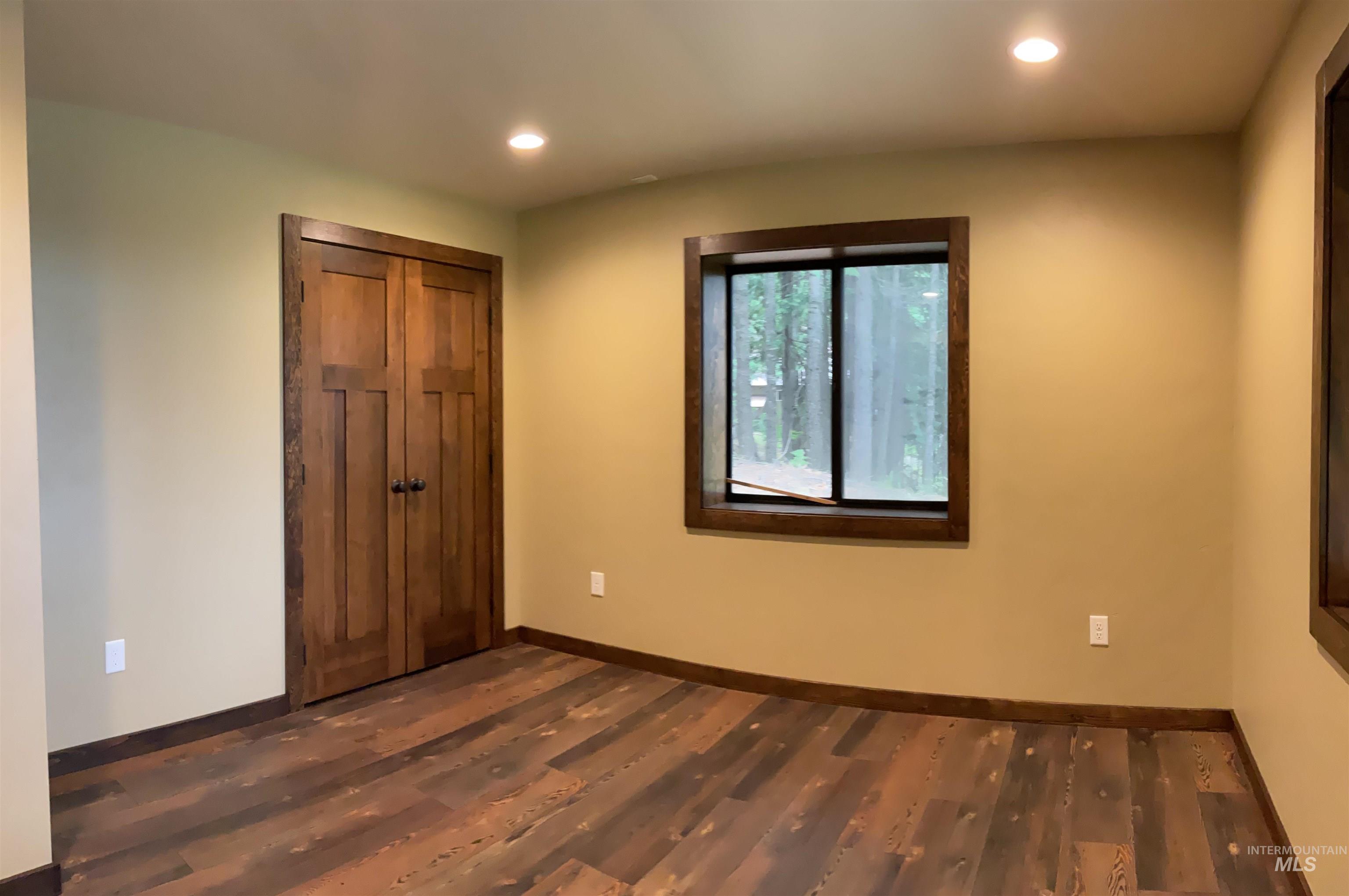 6125 Freeman Creek Road Lenore, ID 83541 - Photo 33 of 44 Spacious room featuring wood-finish flooring, two large windows with dark wood trim, and neutral-toned walls