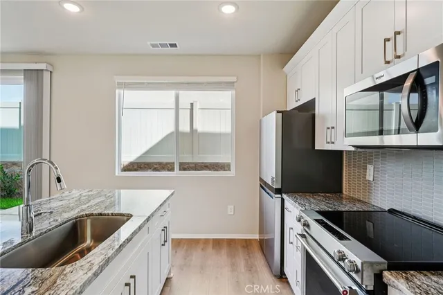 a kitchen with stainless steel appliances granite countertop a sink stove and refrigerator