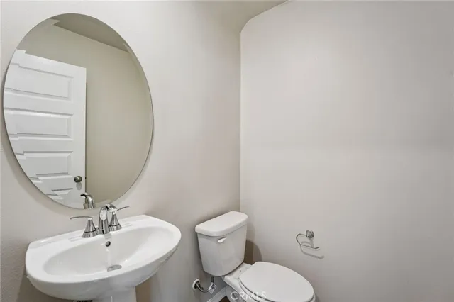 a bathroom with a toilet a sink and mirror