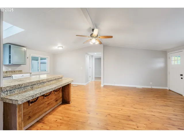 a view of kitchen with kitchen island a sink wooden floor and a fireplace
